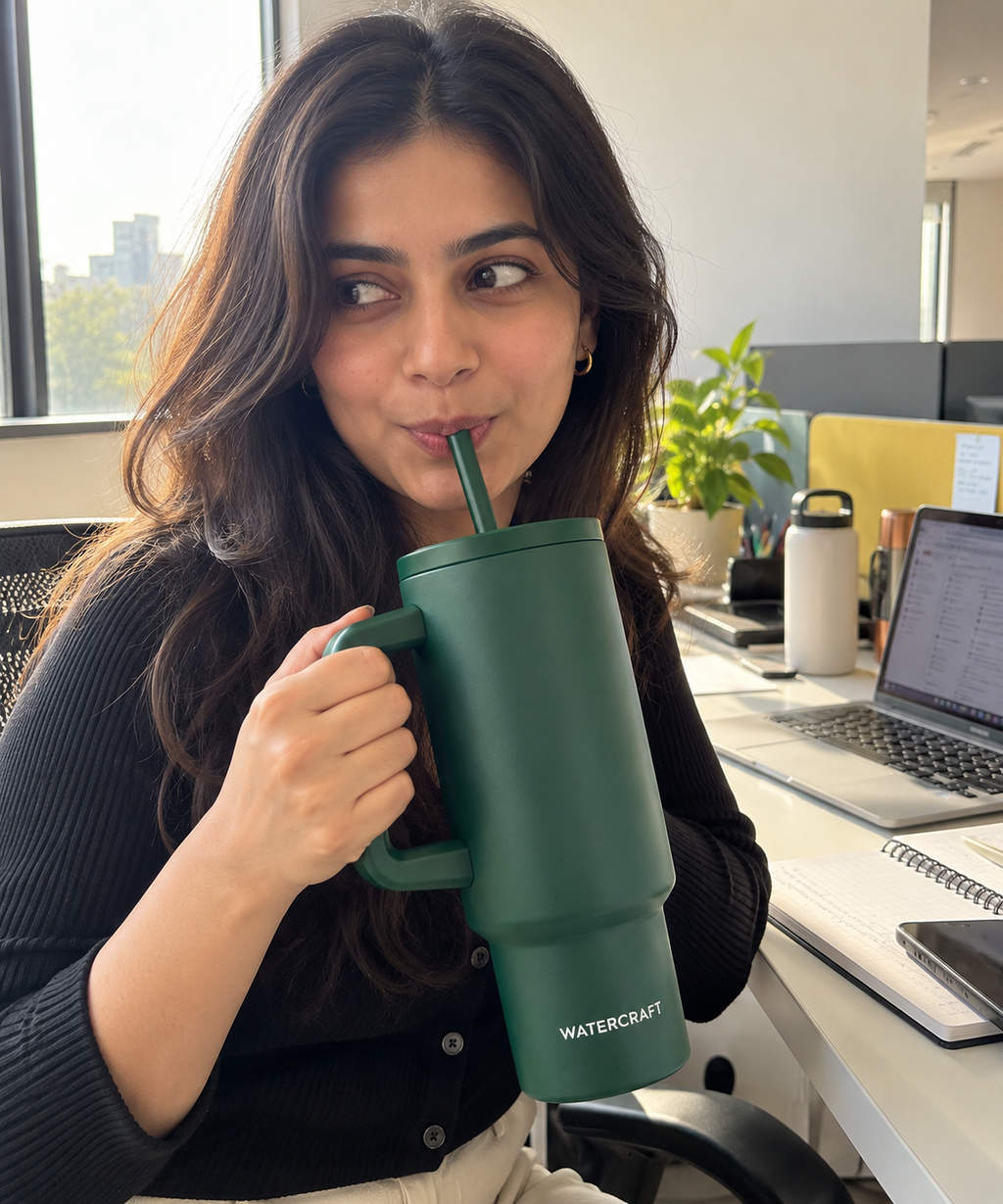 Woman holding WaterCraft Aura green tumbler by the handle at the office - UGC